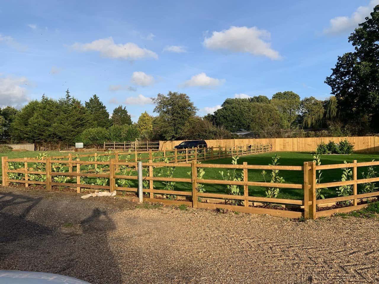 This is a photo of post and rail fencing with a gravel board installed at the base to create a flower bed, and at the rear is feather edge fencing along the edge of the garden. All works carried out by Fast Fix Fencing Cottenham